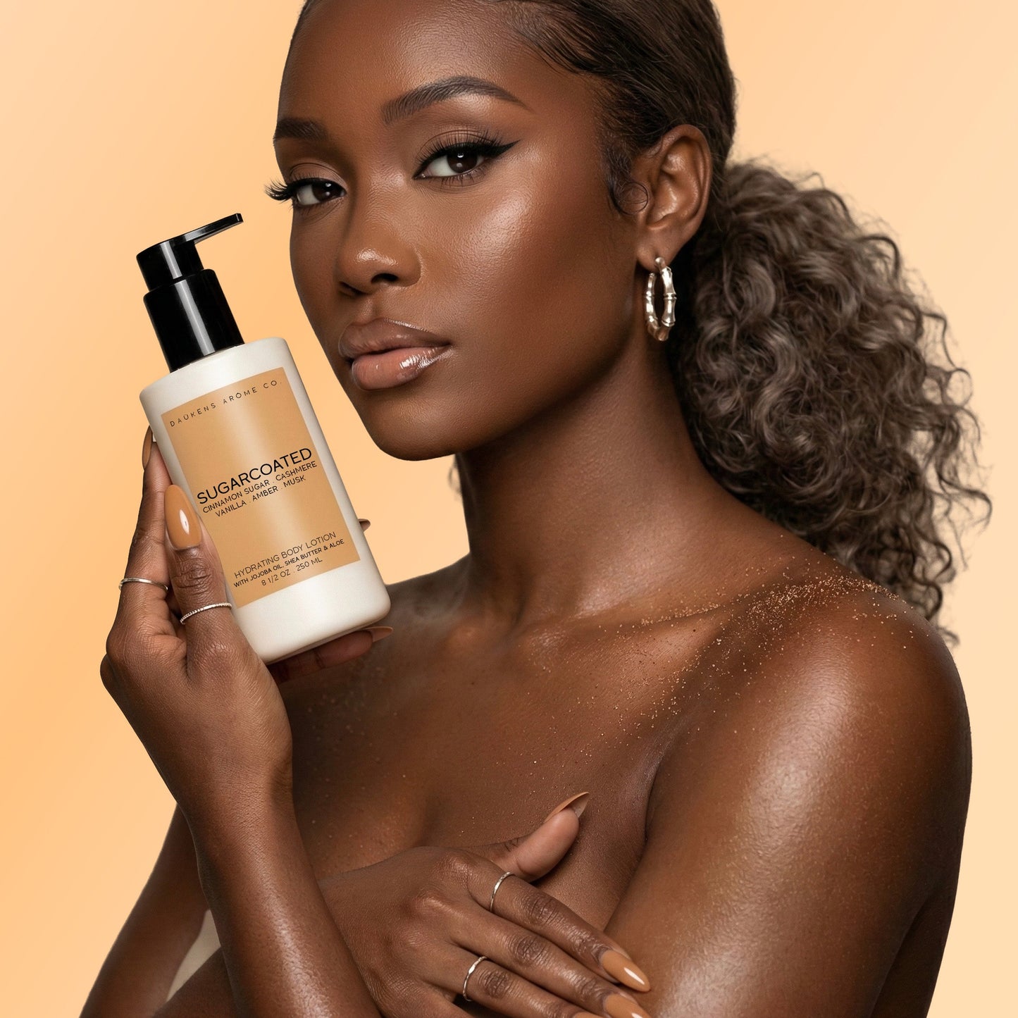 Woman holding a bottle of body lotion product against a beige background