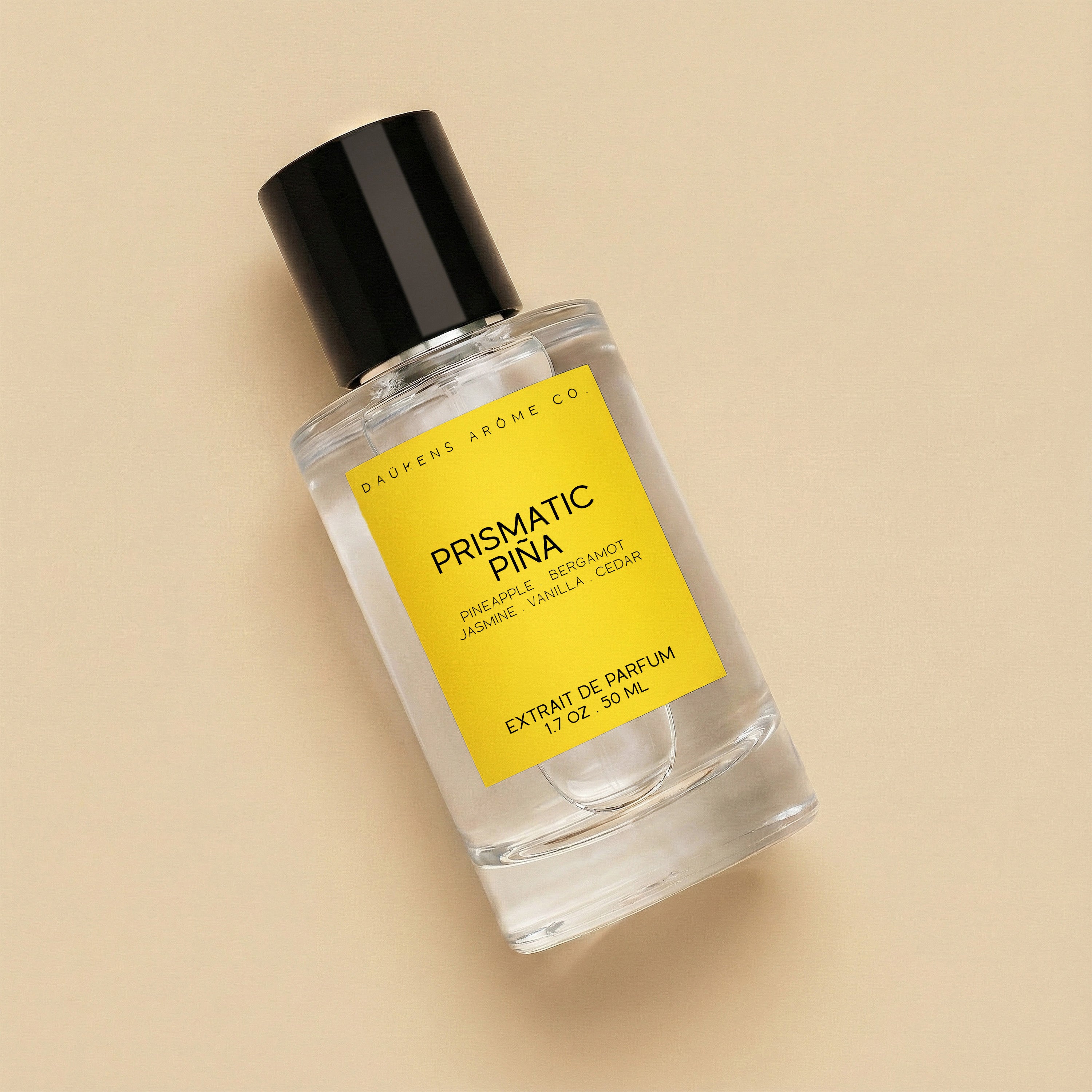 Perfume bottle labeled 'Prismatic Pina' on a beige background.